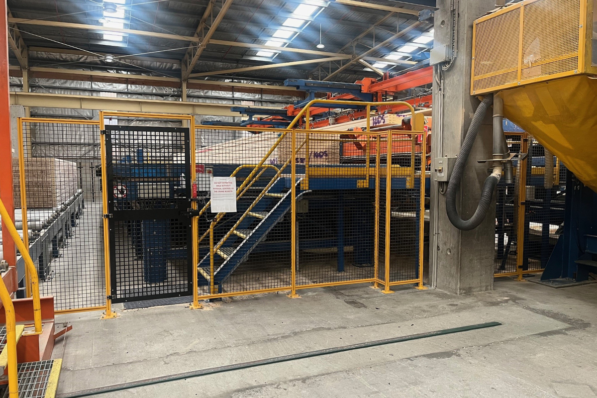 Machine guarding with mesh panels and access gate.